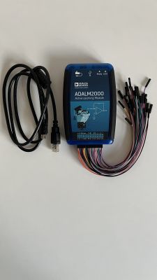 Moduł ADALM2000 z przewodami i kablem USB na jasnym tle