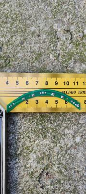 Złamany zielony obwód drukowany z komponentami, na tle żółtej linijki.