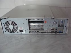 Tył obudowy komputera IBM PC 300 z portami i kratką wentylatora; tekst ogłoszenia w lewym górnym rogu.