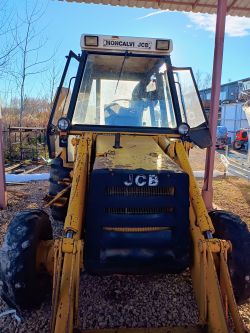 Żółty koparko-ładowarka JCB 3CX z 1982 roku, widok z przodu.