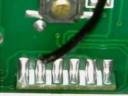 Close-up of a PCB with a soldered black wire.