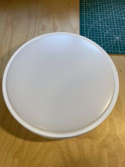 White Ceiling Lamp on Wooden Tabletop White plastic ceiling lamp on a wooden tabletop.