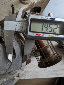 Cyfrowa suwmiarka mierząca metalowy przedmiot, wskazanie 14.52 mm.