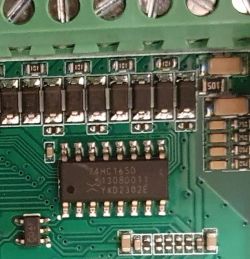 Zdjęcie płytki drukowanej z widocznymi elementami elektronicznymi, w tym układ 74HC165D.
