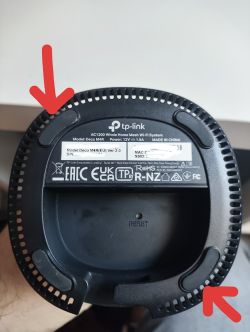 Spód urządzenia TP-Link Deco M4 z zaznaczonymi śrubami pod gumkami.