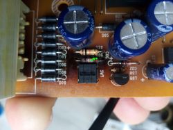 Zbliżenie płytki PCB z kondensatorami i rezystorem C06/R06 zaznaczonym zielonymi kropkami