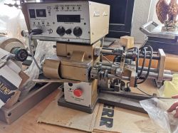 Maszyna do precyzyjnej obróbki metalu z elektronicznym panelem sterującym na stole roboczym.