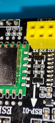 Close-up of a PCB with a soldered ESP-12F module and a yellow connector.