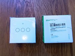 Wi-Fi Three-Way Switch with Tuya T34 Chip Three-way switch and box on a wooden floor.