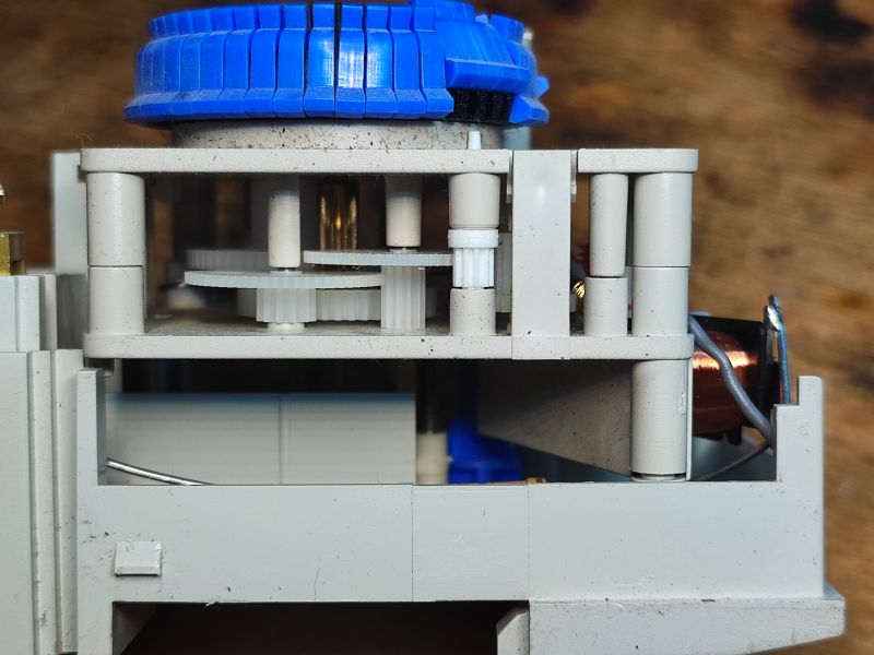 Wnętrze mechanicznego programatora czasowego Theben z widocznymi przekładniami.