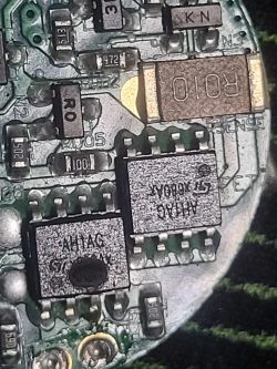 Zbliżenie na uszkodzoną płytkę elektroniczną z widocznymi elementami.