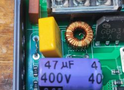 Close-up of power supply interior with coil, 47 µF 400 V capacitor, and bridge rectifier