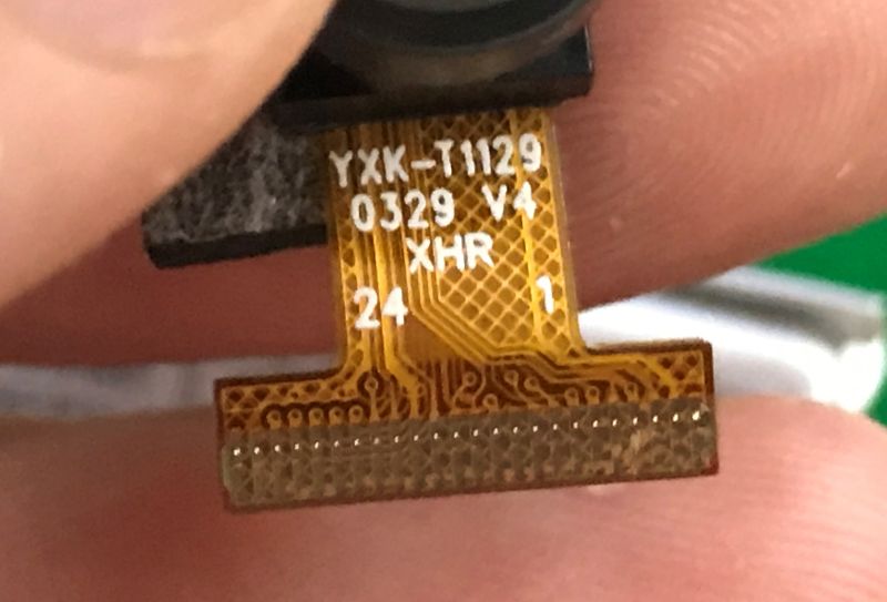 Close-up of FPC ribbon cable with label YXK-T1129 and electrical connector