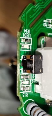 PCB with Switch and Labels Close-up of a PCB with a visible button and components labeled LED1 R14.