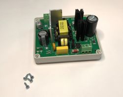 Elektroniczna płytka zasilacza w plastikowej obudowie z widocznymi kondensatorami, radiatorami i wkrętami.