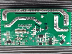 Photo of a green printed circuit board with visible traces and electronic components.