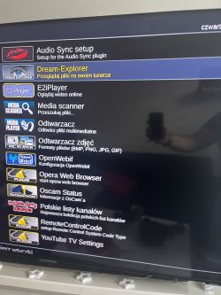 Ekran telewizora z menu ustawień i aplikacji, w tym Dream-Explorer.