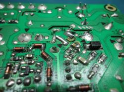 Close-up of a circuit board with visible electronic components, including capacitors and resistors.