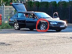 Samochód na parkingu z otwartymi drzwiami i bagażnikiem.