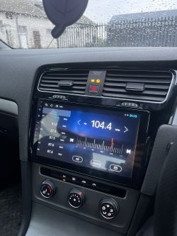 Kokpit samochodu z radiem na częstotliwości 104,4 MHz i kontrolkami poduszek powietrznych.