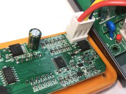 Zbliżenie na płytkę drukowaną stacji lutowniczej z widocznymi elementami elektronicznymi i złączem przewodów.