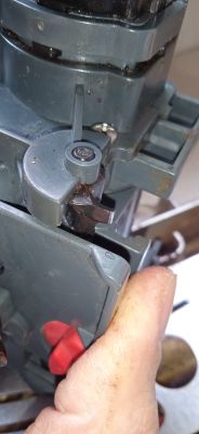 Zbliżenie na mechanizm zaparzacza ekspresu do kawy z widocznym ślimakiem oraz śladami zużycia i brudu.