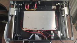 Widok wnętrza urządzenia do programowania mikrokontrolerów z widocznymi elementami mechanicznymi i okablowaniem.
