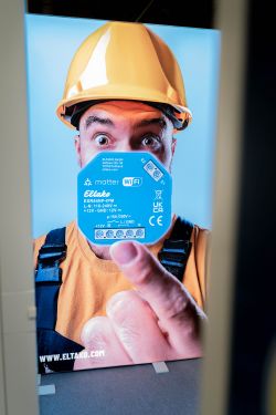 Poster of a person in a hard hat holding an Eltako module with Matter and Wi‑Fi logos