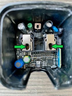 Inside view of a plug housing with visible electronic components and marked arrows.