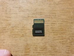 Tylna strona karty microSD bez obudowy na drewnianym tle