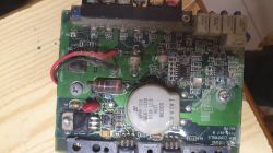 Zdjęcie płytki drukowanej z różnymi elementami elektronicznymi.