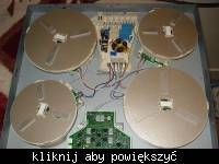 The image shows an electronic device with four large coils and a circuit board connected by wires.