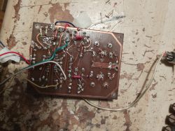 Płytka drukowana z elementami elektronicznymi i lutowanymi przewodami na starym blacie roboczym