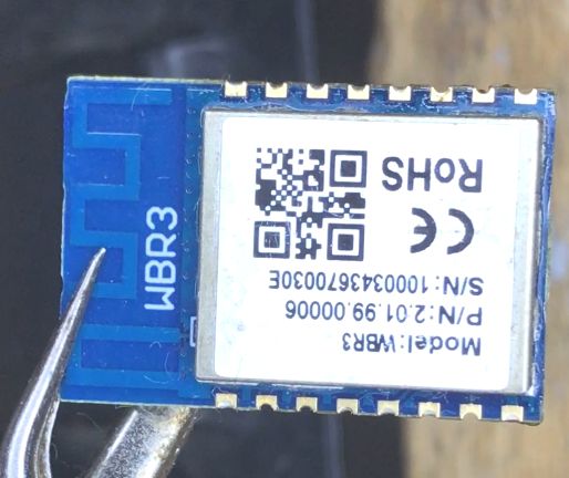 WBR3 electronic module held by metal tweezers.