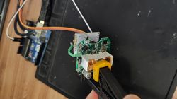PCB and Arduino Uno connected with wires on a black surface
