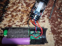 Widok otwartej lampki LED z widocznymi komponentami elektronicznymi i przewodami wewnątrz.