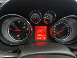 Close-up of a car dashboard with an electronic display and analog gauges.