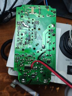 Green circuit board with removed components, shown up close.