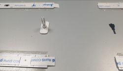 Fragment maty z soczewkami Fresnela na białym tle z kilkoma elementami z tworzywa sztucznego oraz paskami papieru.