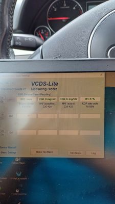 Tablet z programem VCDS-Lite pokazującym parametry EGR, na tle wnętrza samochodu.