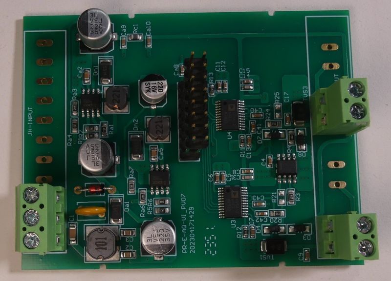 Zielona płytka drukowana PCB z różnymi elementami elektronicznymi, złączami i kondensatorami.