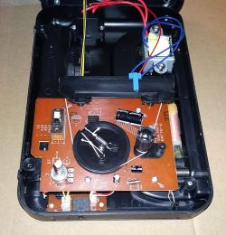 Wnętrze urządzenia elektronicznego z odsłoniętą płytą obwodową.