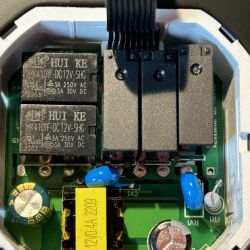 Inside of Thermostat with HUI KE Relays Close-up of the inside of a thermostat with visible relays and other electronic components.