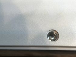 Screw in Electrical Device Casing Screw in a white electrical device casing.