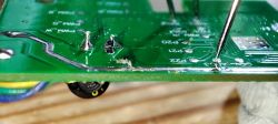 Circuit Board with Soldered Points Close-up of a green circuit board with protruding wires and soldered points.