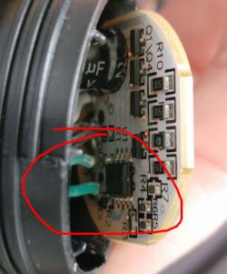 Close-up of a circuit board fragment with visible electronic components and traces. A marked area with the DO (Data Out) label.