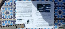 Image of a user manual with an electrical schematic and circuit diagram, lying on a blue-and-white tiled surface.