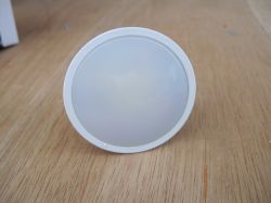 Plastic Cover on Wooden Surface White, round, plastic cover on a light wooden background.