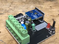 Close-up of a circuit board with a soldered electronic module and LED.