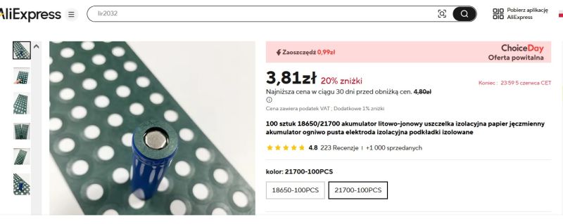 Bateria cylindryczna 21700 stojąca na zielonej macie z otworami, w tle pojedyncze arkusze z wyciętymi okrągłymi podkładkami.
